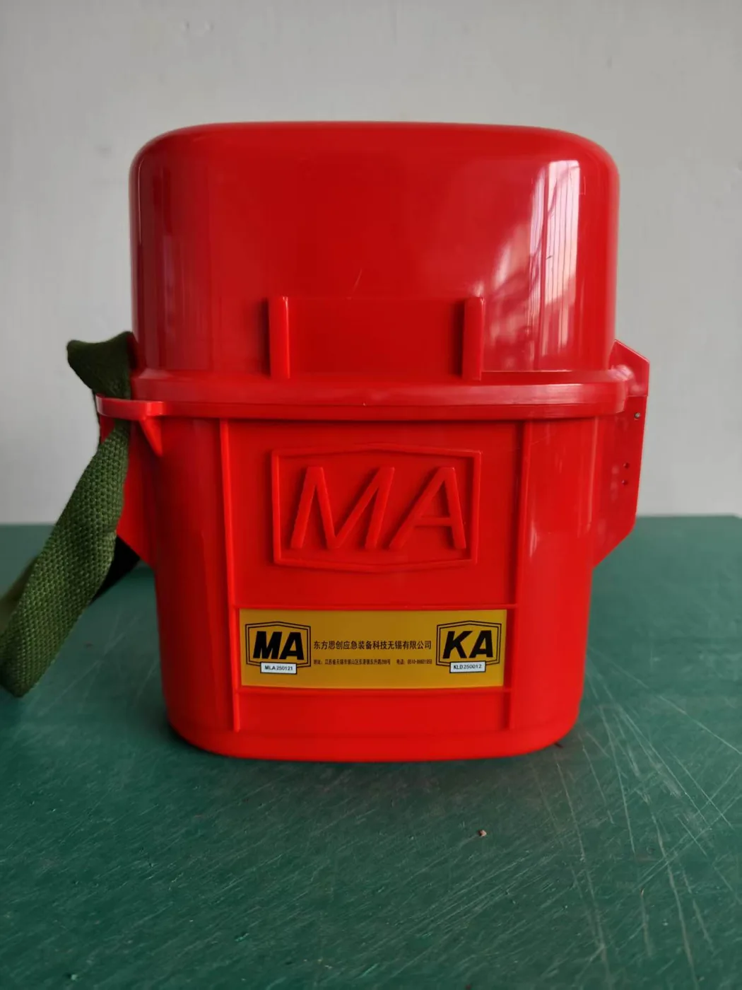 红色隔绝式压缩氧气自救器，壳体压印 MA 标志，黄色铭牌上有 MA 与 KA 编号及生产企业名称